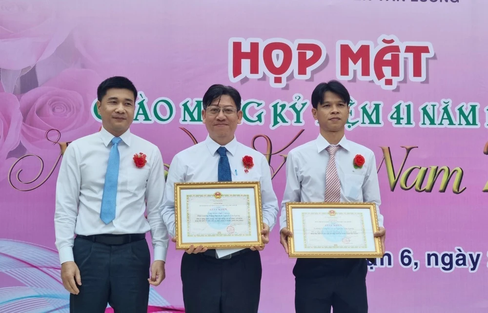Lãnh đạo Bảo hiểm xã hội Thành phố Hồ Chí Minh tuyên dương, khen thưởng thầy hiệu trưởng và tập thể giáo viên Trường THCS Nguyễn Văn Luông, Quận 6. (Ảnh: TTXVN phát)