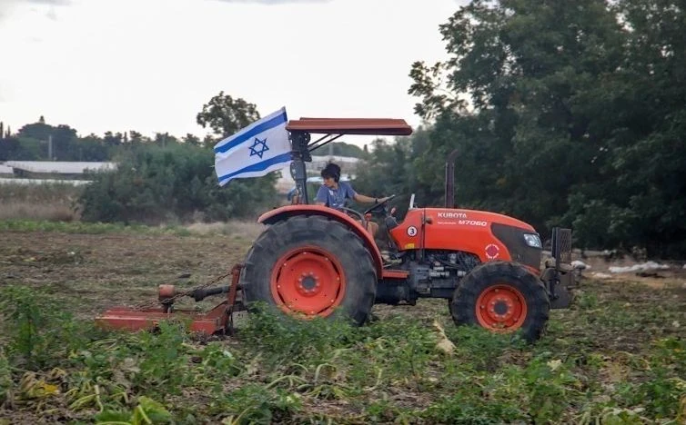 Một nhân viên tình nguyện lái máy cày tại một trang trại miền Trung Israel. (Ảnh: Vũ Hội/TTXVN)
