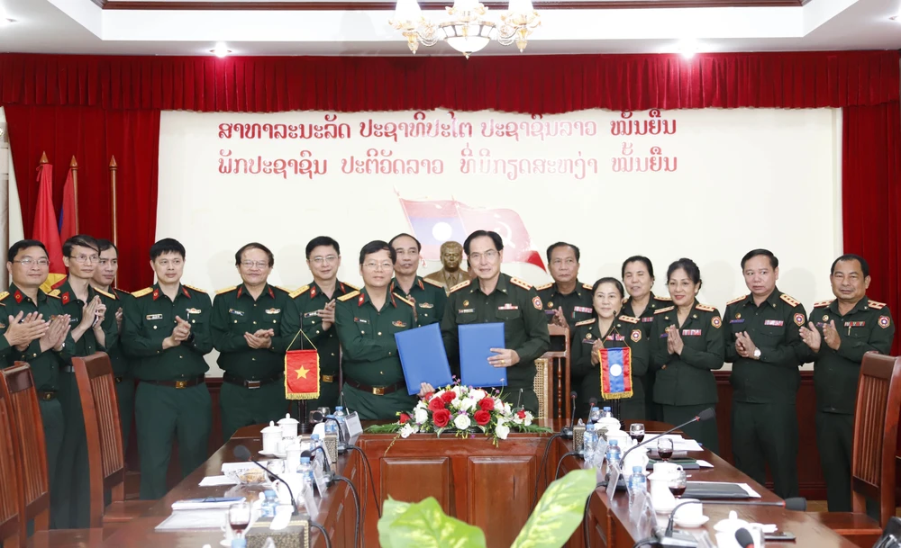 Đại diện Bệnh viện Trung ương 103 QĐND Lào (phải) và đại diện Bệnh viện Quân y 103/Học viện Quân y, QĐND Việt Nam ký Biên bản làm việc. (Ảnh: Phạm Kiên/TTXVN)