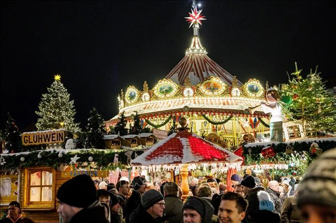 Du khách tham quan và mua sắm tại chợ Giáng sinh ở Dresden, Đức. (Ảnh: AFP/TTXVN)
