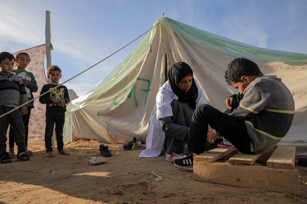 Nhân viên y tế khám cho một em nhỏ tại bệnh viện dã chiến ở thành phố Rafah, miền Nam Dải Gaza, ngày 8/1/2024. (Ảnh: THX/TTXVN)