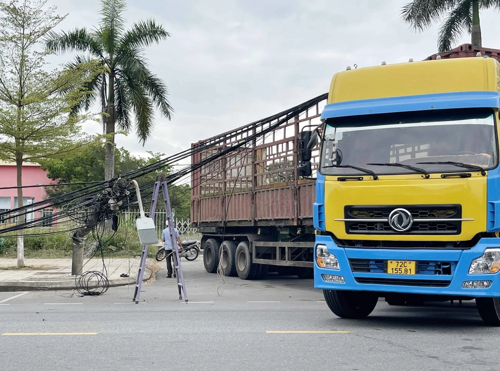 Xe tải vướng vào dây điện đường Nguyễn Văn Linh, phường Trương Quang Trọng làm đổ 4 trụ điện. (Ảnh: Phạm Cường/TTXVN)