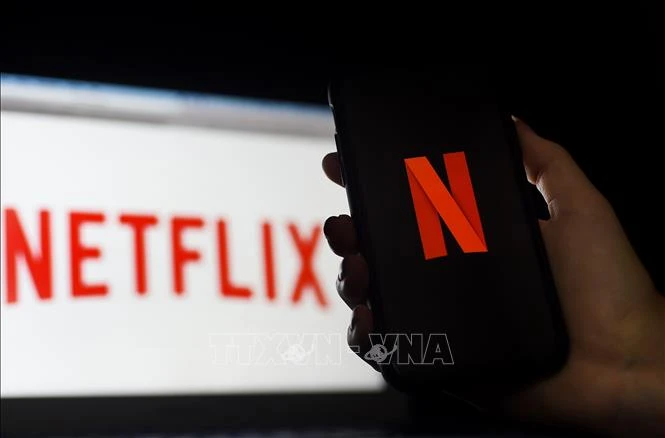 Biểu tượng Netflix trên màn hình máy tính và điện thoại di động. (Ảnh: AFP/ TTXVN)