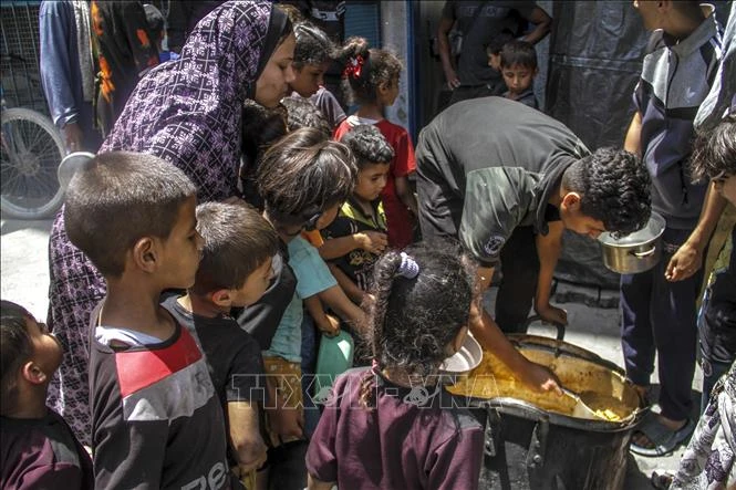 Các em nhỏ chờ được phát thức ăn cứu trợ tại trại tị nạn Jabalia, Dải Gaza. (Ảnh: THX/TTXVN)