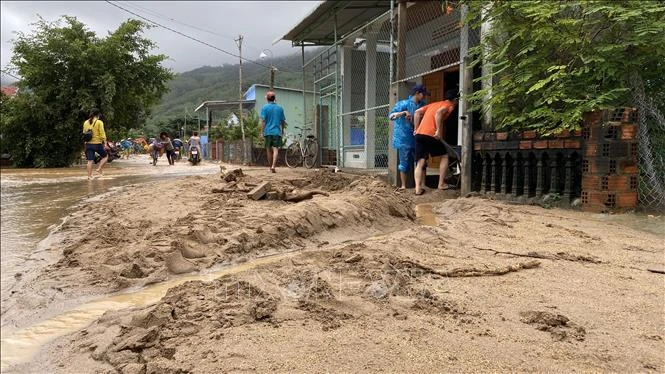Bùn đất dày trên 30cm tràn xuống đường bê tông thôn Chánh Thắng. (Ảnh tư liệu: Tường Quân/TTXVN)