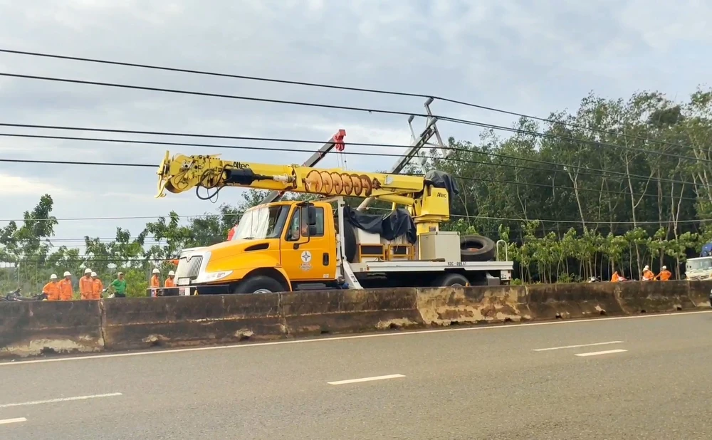 Hàng loạt trụ điện trên đường ĐT.741 bất ngờ bị gãy đổ. (Ảnh TTXVN phát.)