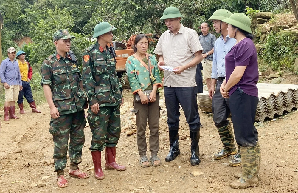 Ông Nguyễn Thành Công, Phó Chủ tịch UBND tỉnh Sơn La (đứng giữa) thăm hỏi, động viên thân nhân gia đình có người mất tích do mưa lũ, đất sạt lở vùi lấp ở xã Chiềng Nơi, huyện Mai Sơn, tỉnh Sơn La. (Ảnh: TTXVN phát)