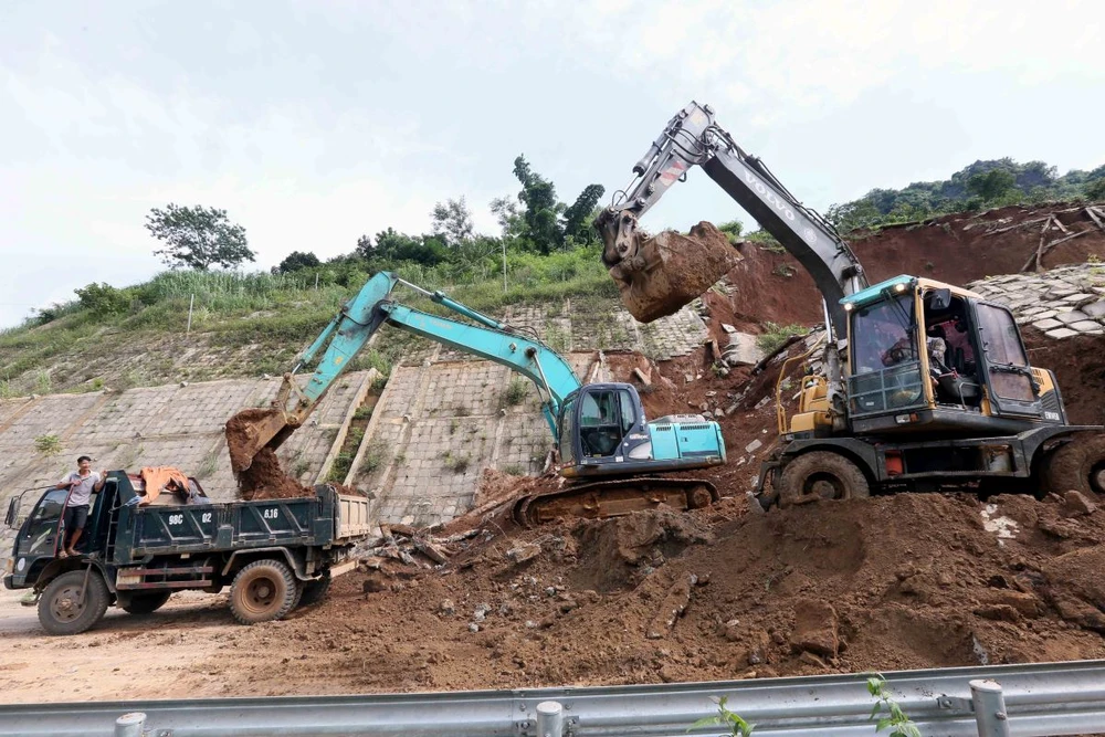 Máy xúc, ôtô được huy động để xúc, ủi, san gạt đảm bảo thông tuyến nhanh nhất.(Ảnh: Quang Quyết/TTXVN)