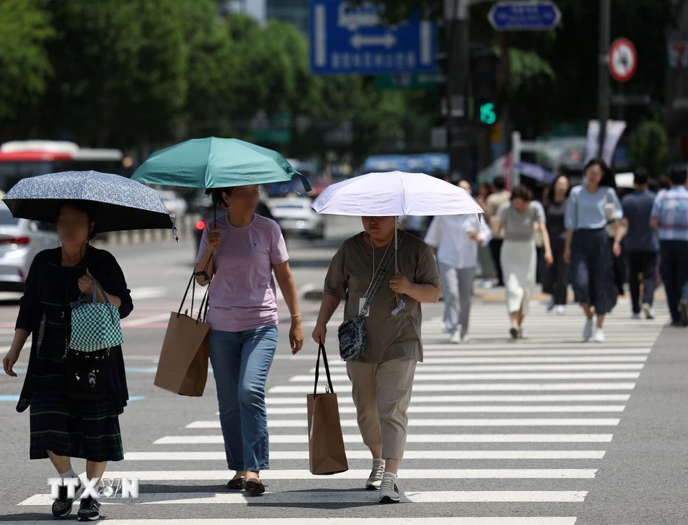 Người dân che ô tránh nắng nóng trên đường phố tại Seoul, Hàn Quốc. (Ảnh: Yonhap/TTXVN)