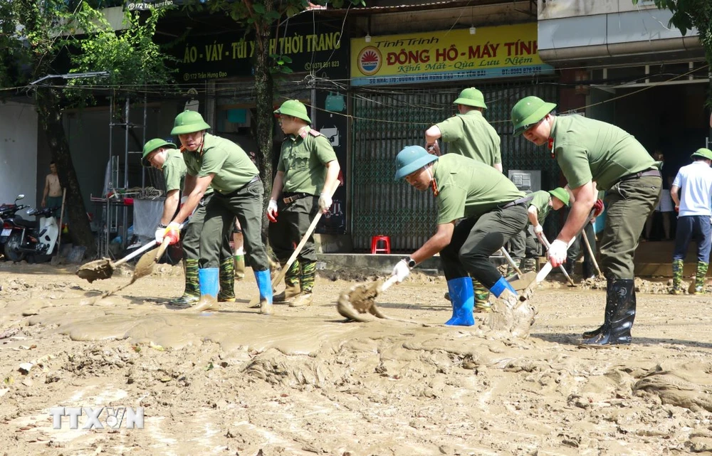 Hàng trăm người gồm bộ đội, công an, dân quân tự vệ, đoàn thanh niên... được huy động hỗ trợ dọn bùn, giúp người dân thành phố Yên Bái sớm ổn định cuộc sống sau đợt lũ. (Ảnh: Tuấn Anh/TTXVN)