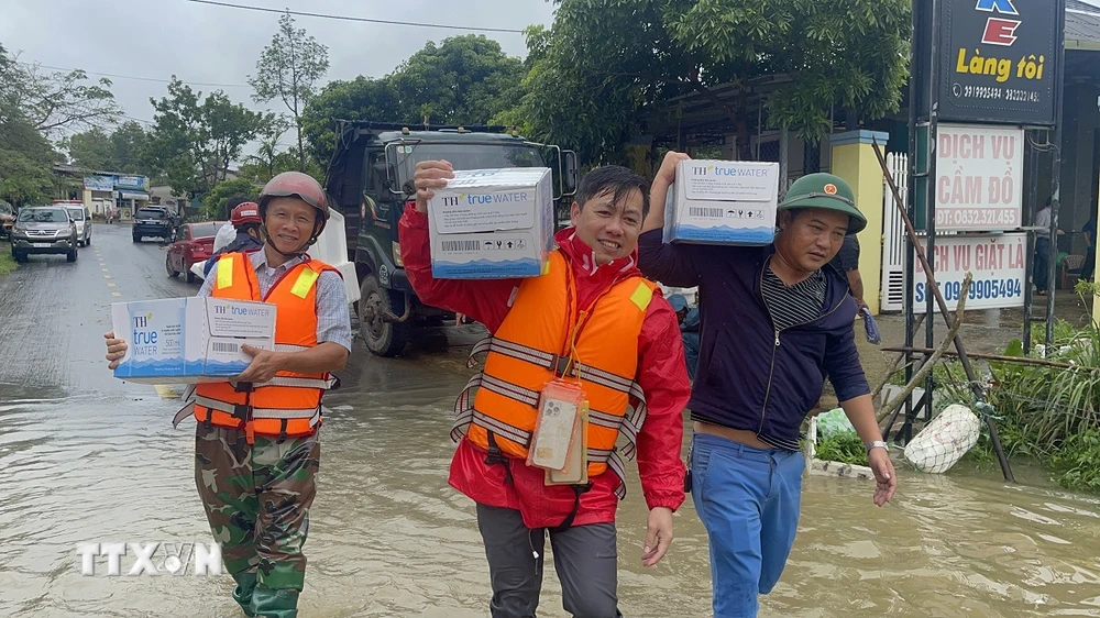 Các lực lượng chức năng và người dân chuẩn bị lương thực hỗ trợ bà con vùng ngập lụt. (Ảnh: Thanh Thuỷ/TTXVN)