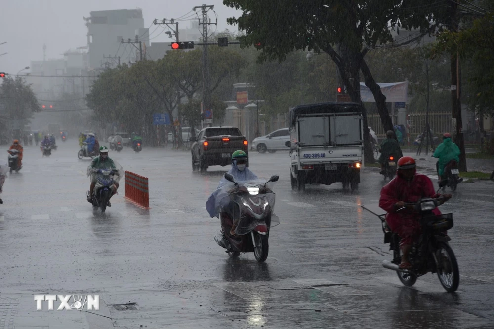 Phương tiện di chuyển gặp khó khăn do mưa lớn. (Ảnh: Văn Dũng/TTXVN)