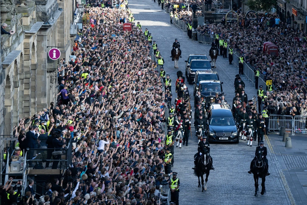 Người dân xếp hàng dài hai bên đường để bày tỏ lòng thành kính khi Linh cữu Nữ hoàng Anh Elizabeth II được rước từ Cung điện Holyroodhouse tới Lâu đài St Giles ở Edinburgh, ngày 14/9/2022. (Ảnh: AFP/TTXVN)