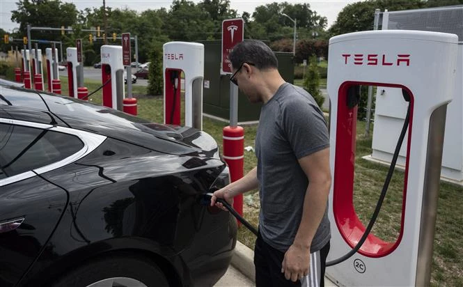 Người dân sạc điện cho ôtô tại một trạm sạc của Tesla ở Arlington, Virginia (Mỹ). (Ảnh: AFP/TTXVN)