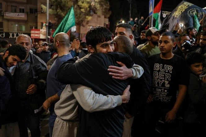 Một tù nhân Palestine (trái) đoàn tụ cùng người thân tại thành phố Ramallah, Bờ Tây sau khi được phóng thích khỏi nhà tù của Israel, ngày 26/11/2023. (Ảnh: AFP/TTXVN)