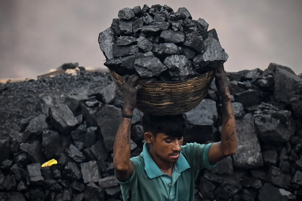 Thu nhặt than đá tại một khu mỏ ở ngoại ô Dhanbad (Ấn Độ) ngày 6/7/2023. (Ảnh: AFP/TTXVN)