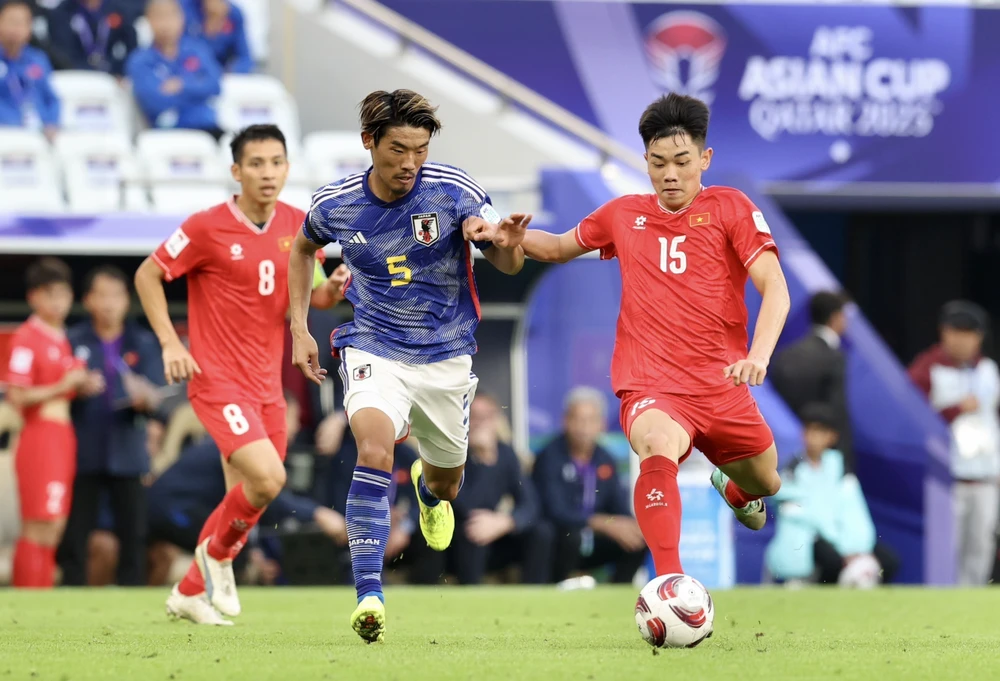 Đình Bắc (số 15) của Tuyển Việt Nam tranh chấp bóng cùng cầu thủ Nhật Bản trong trận đấu tối 14/1/2024 (giờ địa phương) trên Sân Vận động Al Thumama tại Doha (Qatar). (Ảnh: Hoàng Linh/TTXVN)