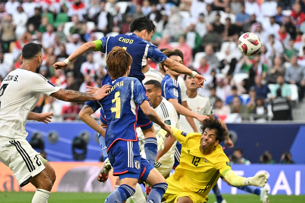 Pha bật cao đánh đầu thành bàn của tiền vệ Nhật Bản Wataru Endo ở phút 90+3 trong trận chạm trán Iraq (áo trắng) ở lượt trận thứ hai bảng D Asian Cup 2023, ngày 19/1/2024. (Ảnh: AFP/TTXVN)