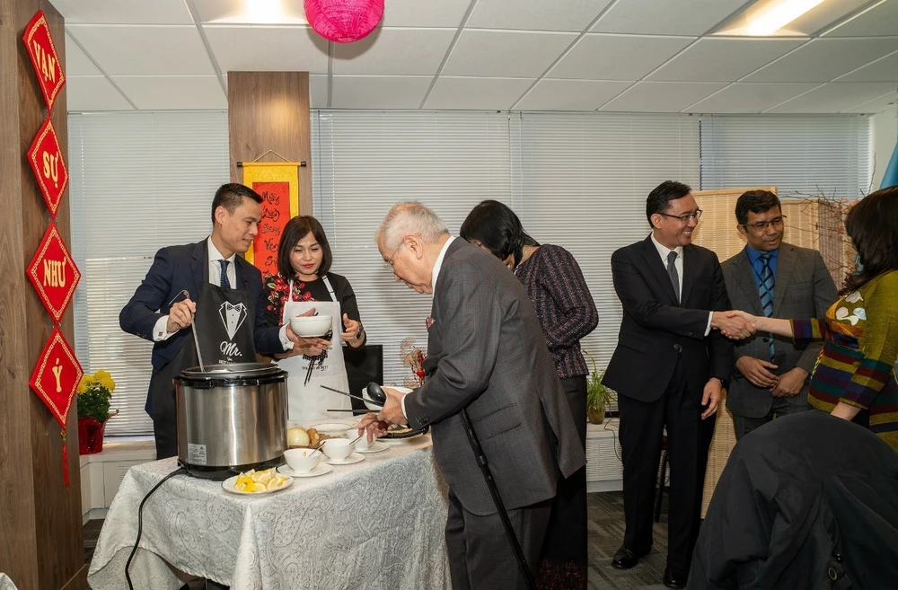 Đại sứ Đặng Hoàng Giang - Trưởng Phái đoàn Việt Nam tại Liên hợp quốc cùng phu nhân giới thiệu món ăn truyền thống của Việt Nam tới các Đại sứ, Đại biện của Phái đoàn các nước thành viên và quan sát viên ASEAN tham gia buổi chiêu đãi. (Ảnh: Quang Huy/TTXVN)