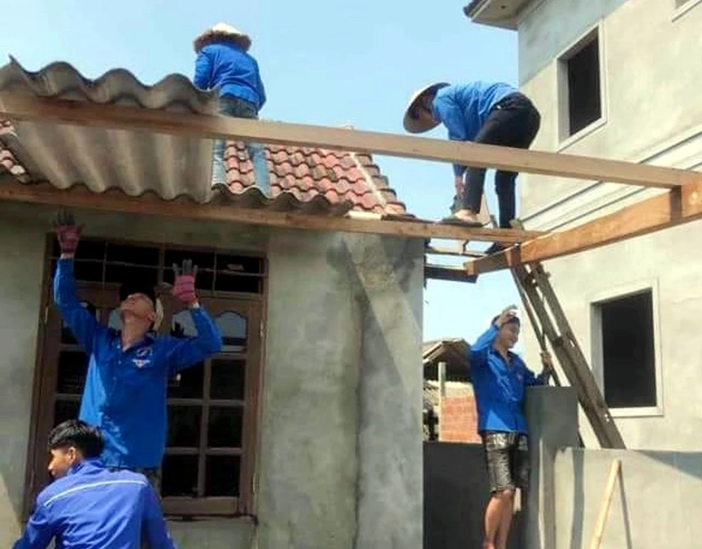 Đoàn thanh niên giúp người dân lợp lại nhà cửa sau lốc lốc xoáy tại Hà Tĩnh. (Ảnh: Công Tường/TTXVN)
