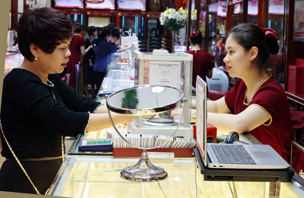 Người dân mua bán vàng tại một cửa hàng kinh doanh vàng Bảo Tín Minh Châu. (Ảnh: Trần Việt/TTXVN)