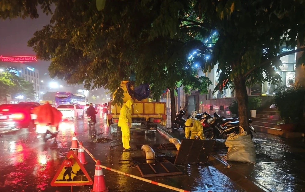 Các đơn vị ứng trực thoát nước ở khu vực đường Minh Khai, quận Hai Bà Trưng trong trận mưa lớn tối 12/5. (Ảnh: TTXVN)