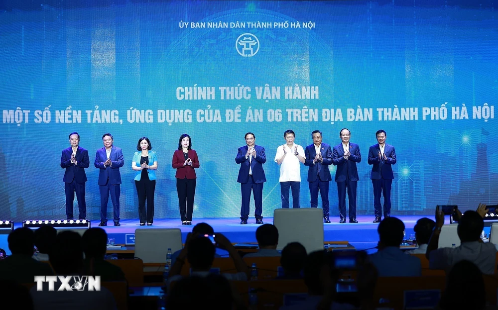 Thủ tướng Phạm Minh Chính và các đại biểu thực hiện nghi thức vận hành các nền tảng, ứng dụng của Đề án 06. (Ảnh: Dương Giang/TTXVN)