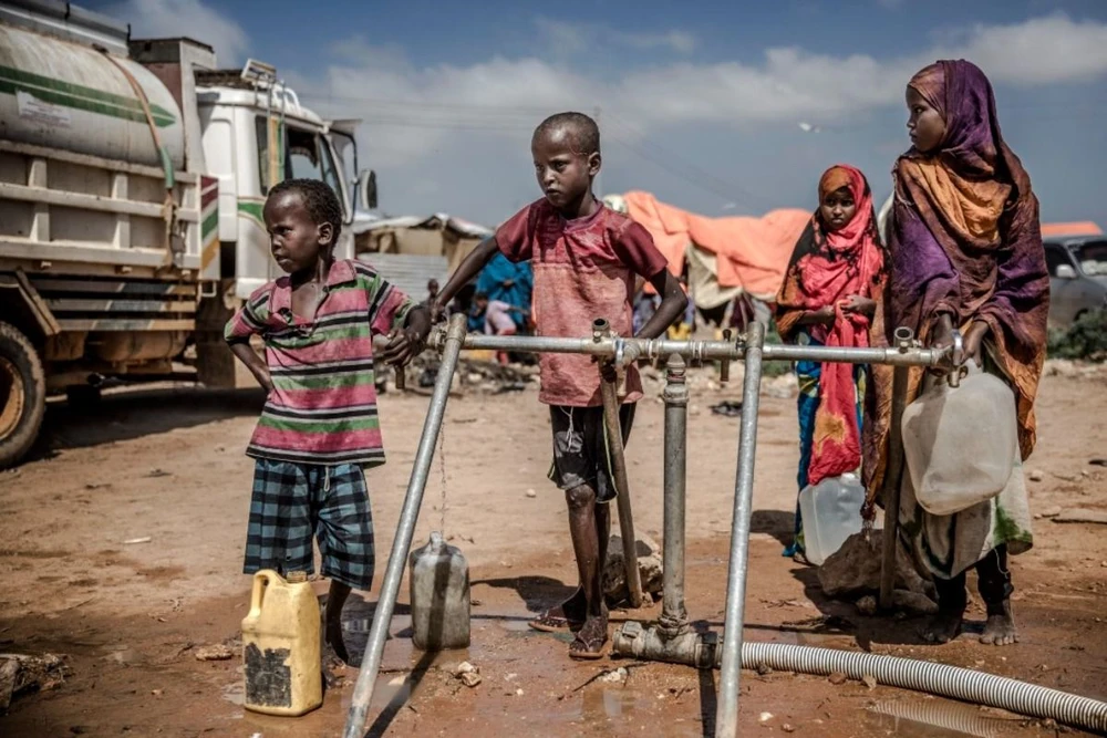 Các em nhỏ lấy nước tại điểm công cộng ở Beledweyne (Somalia). (Ảnh: AFP/TTXVN)