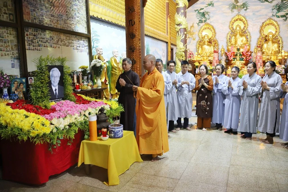 Các tăng ni, phật tử tại Lào đang cùng nhau thắp hương tưởng nhớ Tổng Bí thư Nguyễn Phú Trọng. (Ảnh: Đỗ Bá Thành/TTXVN)