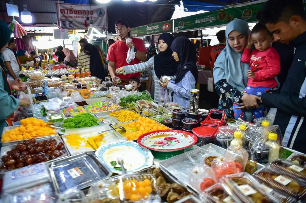 Người dân mua thực phẩm tại khu chợ ở Narathiwat (Thái Lan). (Ảnh: AFP/TTXVN)