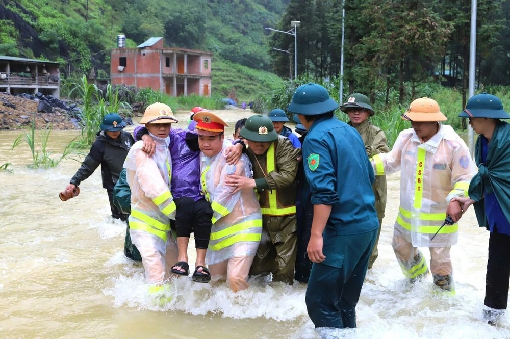 Lực lượng chức năng huyện Mèo Vạc vượt lũ đưa bệnh nhân xuất huyết dạ dày đến bệnh viện kịp thời. (Ảnh: Minh Đức/TTXVN phát)