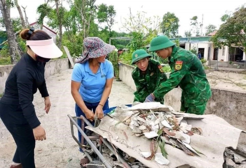 Lực lượng chức năng giúp người dân lợp lại nhà bị tốc mái trong bão số 4 ở huyện Cẩm Xuyên. (Ảnh: TTXVN phát)