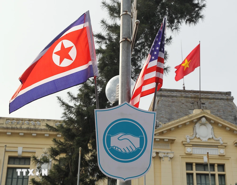 Cờ Mỹ và cờ Triều Tiên, bên dưới là biểu tượng hai bàn tay bắt chặt vào nhau thể hiện tinh thần của cuộc gặp lớn, được treo bên ngoài Nhà khách Chính phủ trên phố Ngô Quyền, Quận Hoàn Kiếm. (Ảnh: Lâm Khánh/TTXVN)