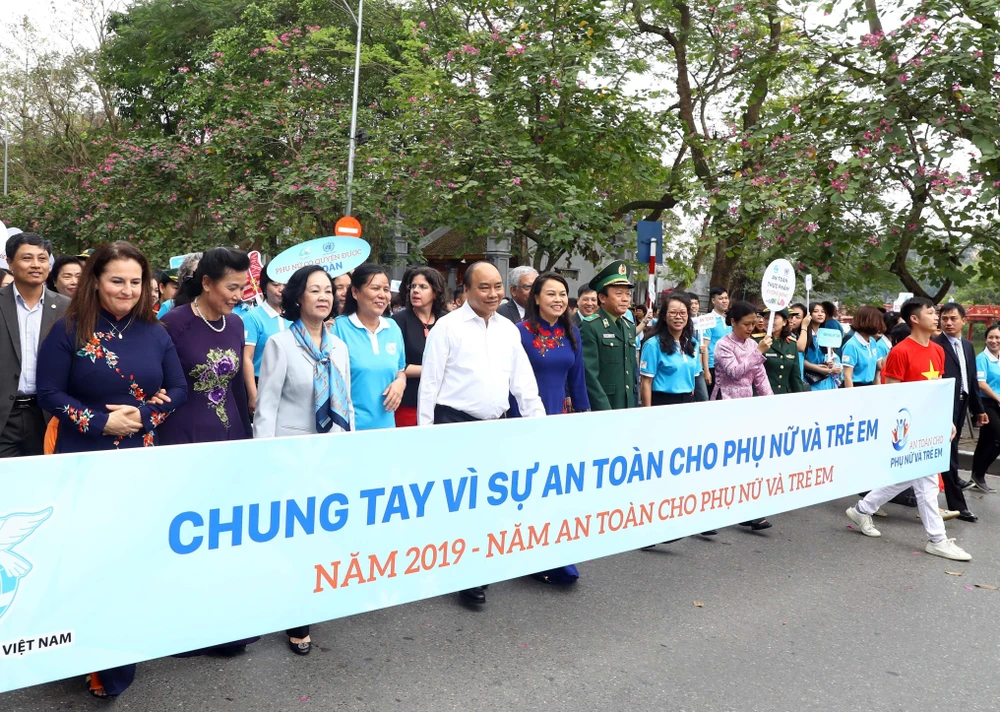 Thủ tướng Nguyễn Xuân Phúc và các đại biểu cùng tham gia đi bộ trên đường Đinh Tiên Hoàng, hưởng ứng Năm an toàn cho phụ nữ và trẻ em. (Ảnh: Thống Nhất/TTXVN)
