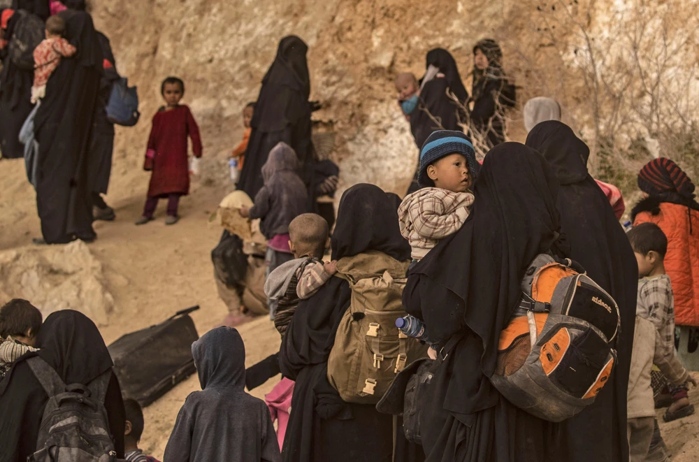 Phụ nữ và trẻ em sơ tán khỏi thị trấn Baghouz, miền đông Syria để tránh các cuộc xung đột ngày 14/3. (Nguồn: AFP/TTXVN)
