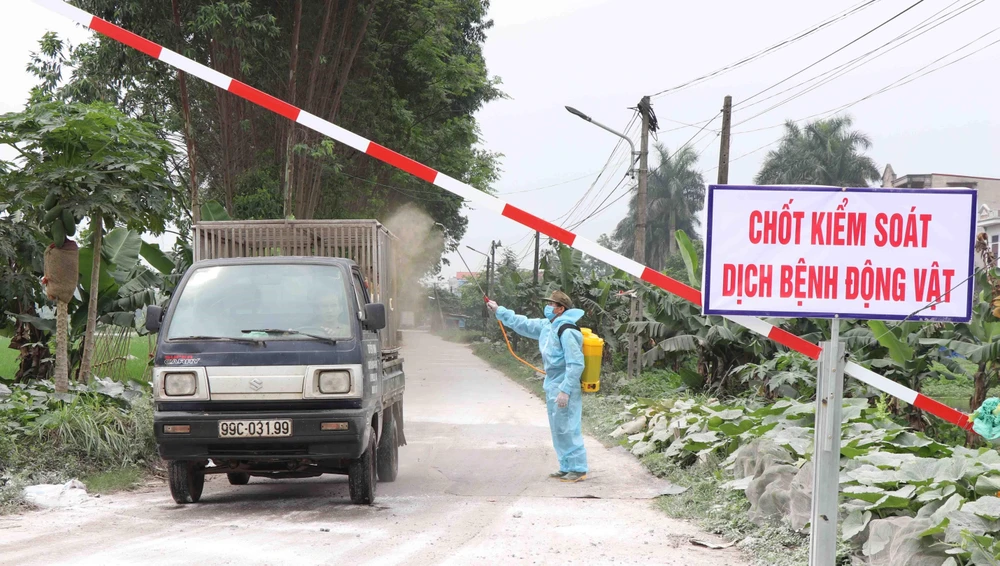 Lực lượng chức năng phường Khắc Niệm, thành phố Bắc Ninh, tỉnh Bắc Ninh phun khử trùng, tiêu độc các phương tiện ra vào địa phương. (Ảnh: Diệp Trương/TTXVN)