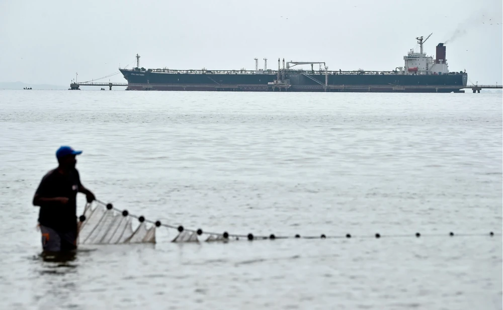 Một ngư dân thả lưới bên một tàu chở dầu ở Venezuela. (Nguồn: Getty Images)