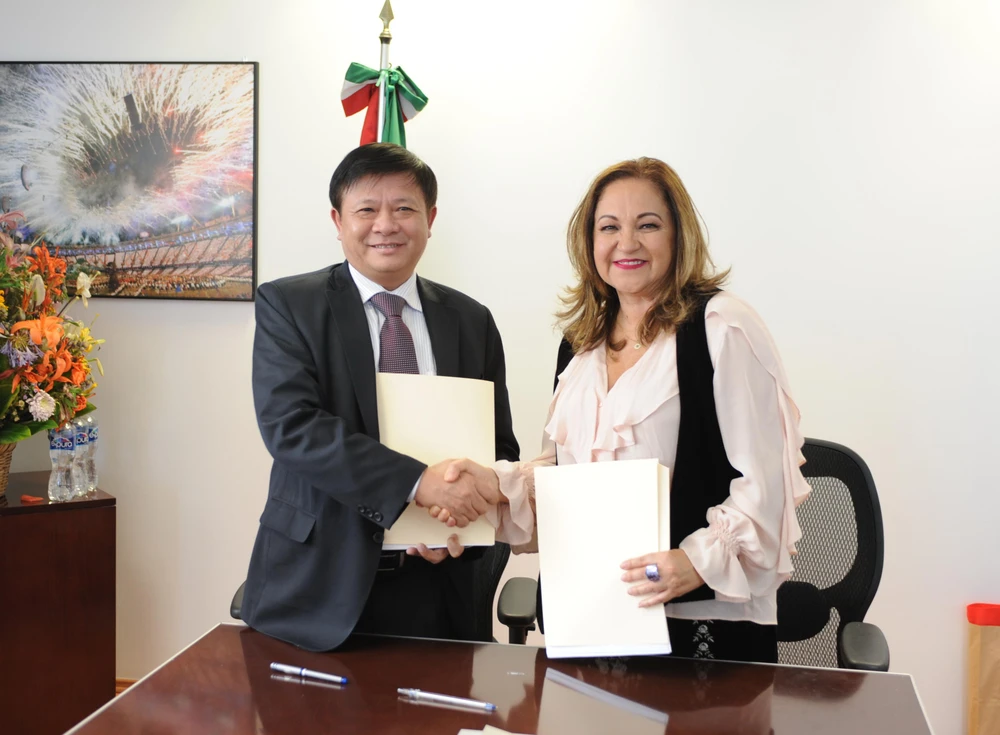 Phó Tổng giám đốc Đinh Đăng Quang và Tổng giám đốc của Notimex Sanjuana Martínez Montemayor trao đổi văn bản ký kết. (Ảnh: Việt Hùng/Vietnam+)