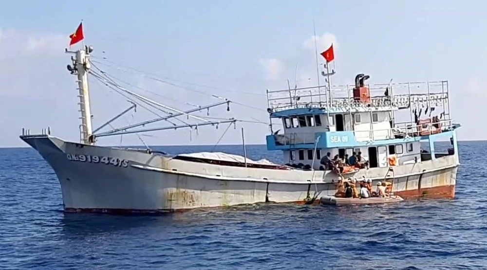 Trong ảnh: Xuồng cứu nạn tiếp cận tàu cá để đưa ngư dân gặp nạn qua tàu SAR 412 để chăm sóc y tế và di chuyển về bờ. (Ảnh: Xuân Nguyên/TTXVN)