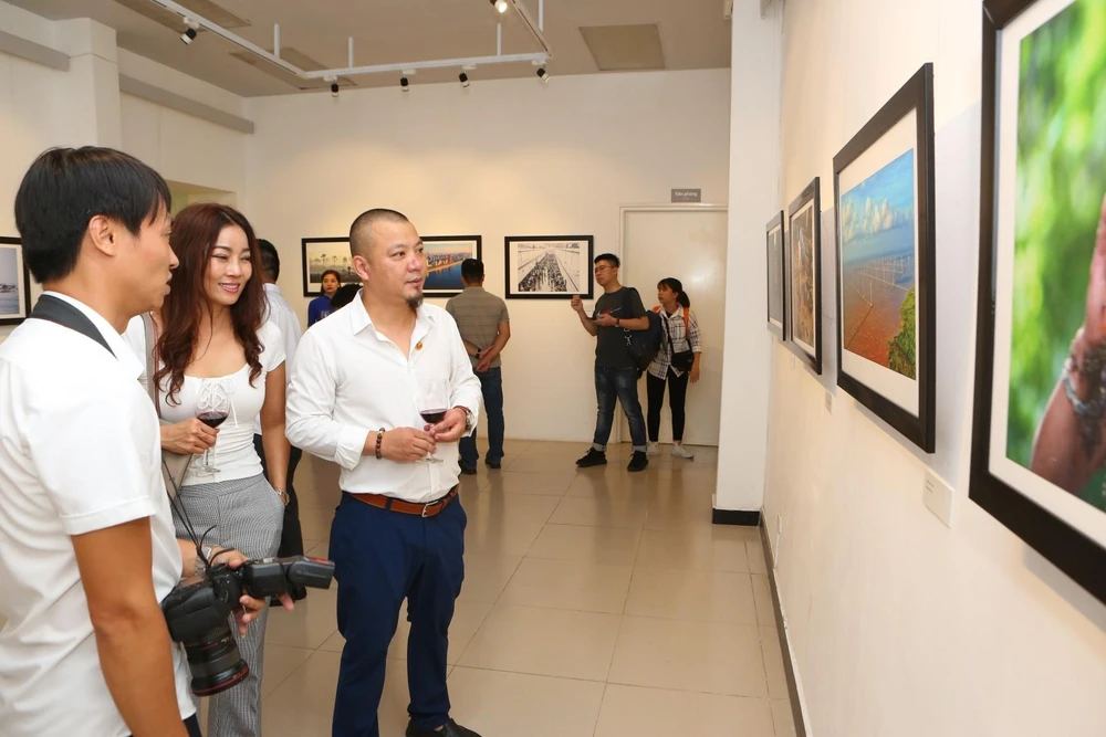 Các đại biểu và du khách tham quan triển lãm ảnh báo chí "Dấu ấn." (Ảnh: Thành Đạt/TTXVN)