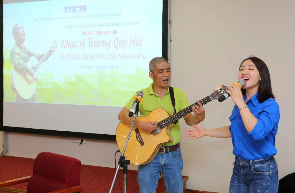 Nhạc sỹ Trương Quý Hải giao lưu hát cùng đoàn viên Thanh niên TTXVN. (Ảnh: Thành Đạt/TTXVN)