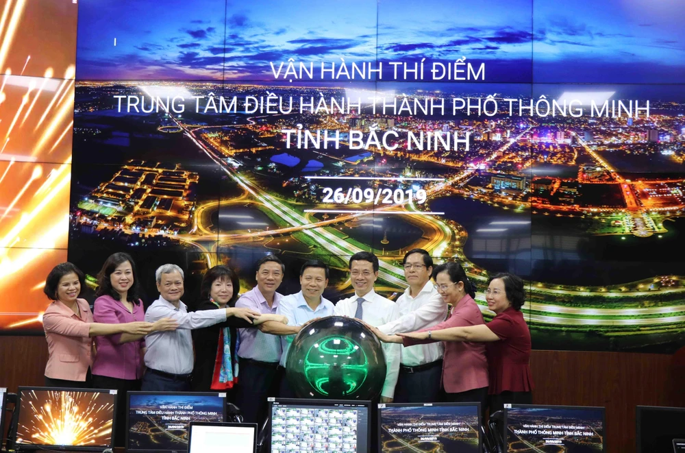 Bộ trưởng Bộ Thông tin và Truyền thông Nguyễn Mạnh Hùng (thứ 4 từ phải) và các đại biểu nhấn nút vận hành thử nghiệm chương trình. (Ảnh: Thanh Thương/TTXVN)