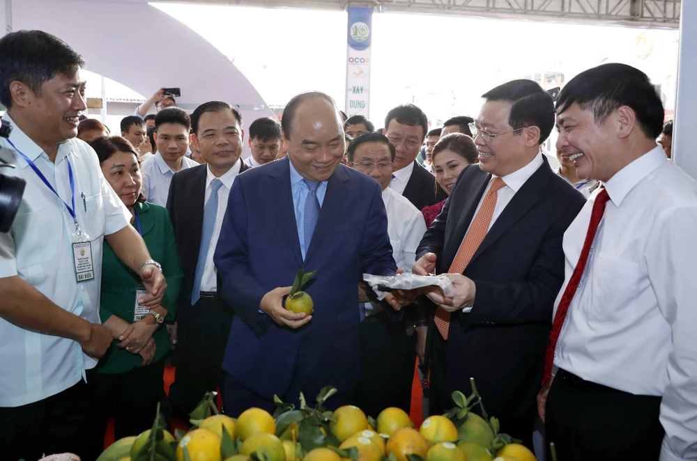 Thủ tướng Nguyễn Xuân Phúc và các đại biểu tham quan các gian hàng trưng bày tại triển lãm. (Ảnh: Thống Nhất/TTXVN)