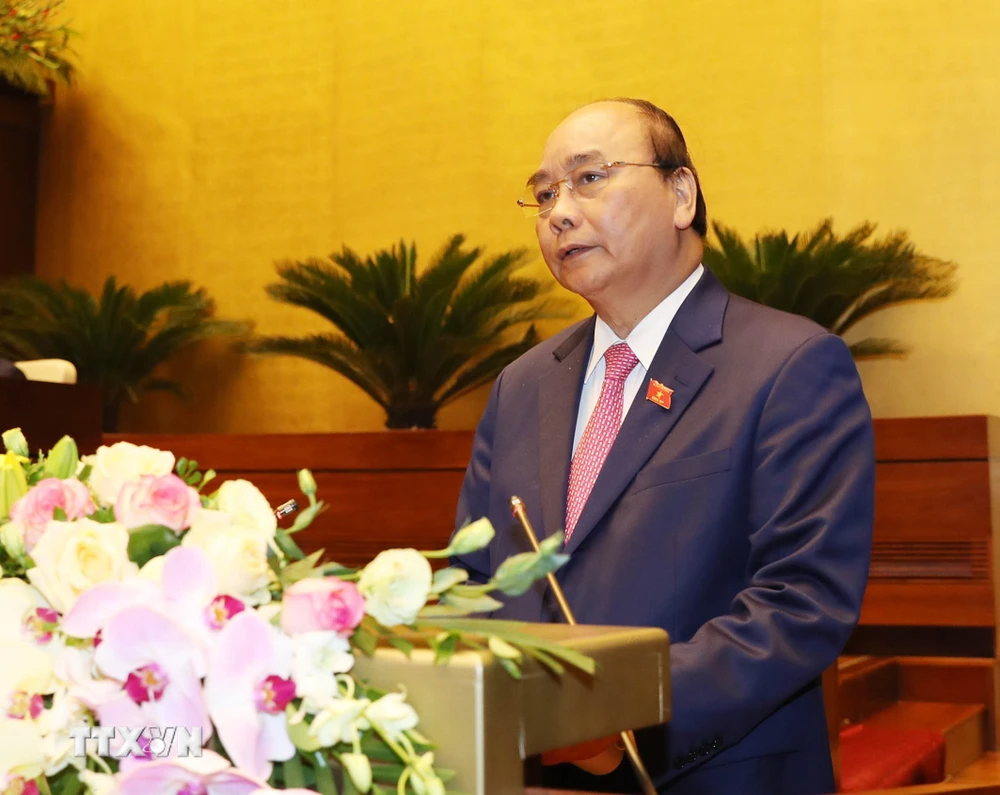Thủ tướng Nguyễn Xuân Phúc đọc báo cáo của Chính phủ. (Ảnh: Trọng Đức/TTXVN)