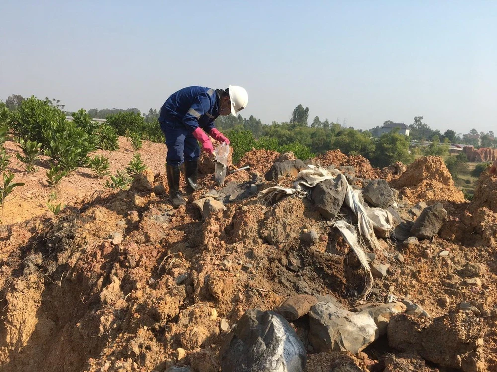 Viện Khoa học và Công nghệ Môi trường lấy mẫu để phân tích thành phần có trong chất thải bị đổ trộm tại thôn Lai Thôn, xã Bắc Sơn (Sóc Sơn, Hà Nội). (Ảnh: Mạnh Khánh/TTXVN)