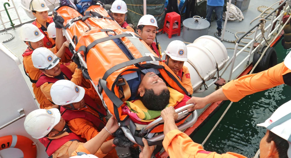 Thuyền viên Syaiful Chandra được đội cứu nạn đưa lên bờ để chuyển đến bệnh viện tiếp tục điều trị. (Ảnh: Nguyễn Dũng/TTXVN)