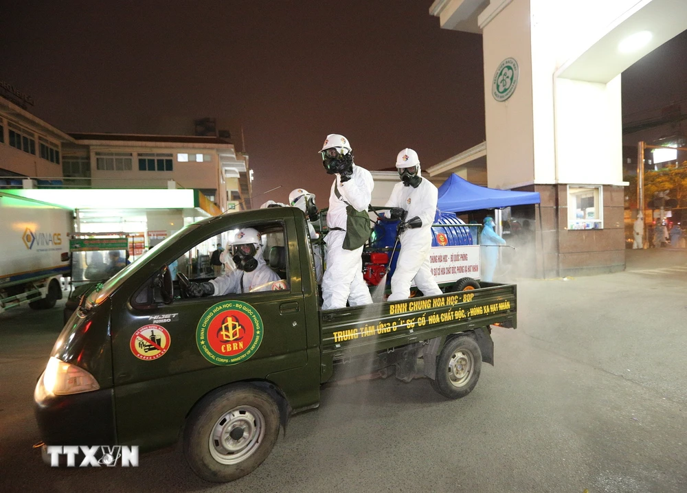 Lực lượng bộ đội hóa học phun hóa chất khử khuẩn khu vực cổng số 1 Bệnh viện Bạch Mai. (Ảnh: Dương Giang/TTXVN)