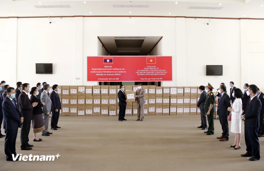 Quang cảnh lễ bàn giao hàng viện trợ của Chính phủ Việt Nam cho Chính phủ Lào để phòng chống dịch COVID-19. (Ảnh: Phạm Kiên/Vietnam+)