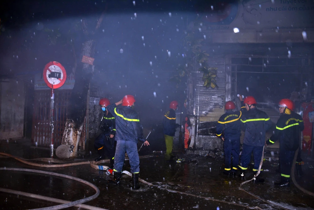 Cán bộ, chiến sỹ Phòng Cảnh sát Phòng cháy chữa cháy và cứu nạn cứu hộ, Công an tỉnh Thừa Thiên-Huế khống chế, dập tắt ngọn lửa trong đêm. (Nguồn: TTXVN phát)