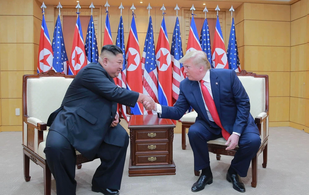 Trong ảnh: Tổng thống Mỹ Donald Trump (phải) và nhà lãnh đạo Triều Tiên Kim Jong-un trong cuộc gặp thượng đỉnh tại làng đình chiến Panmunjom trong Khu phi quân sự (DMZ) ngày 30/6/2019. (Nguồn: AFP/TTXVN)
